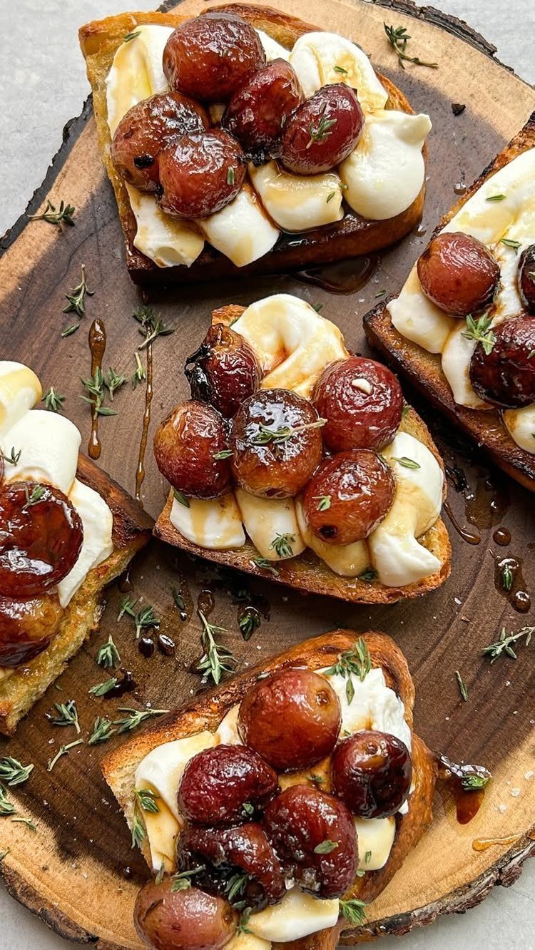 Roasted red grapes and ricotta cheese on toasted crostini with fresh thyme sprigs.