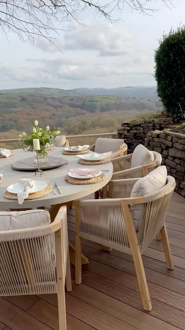 Woven rope dining chairs with beige cushions around a set outdoor table.