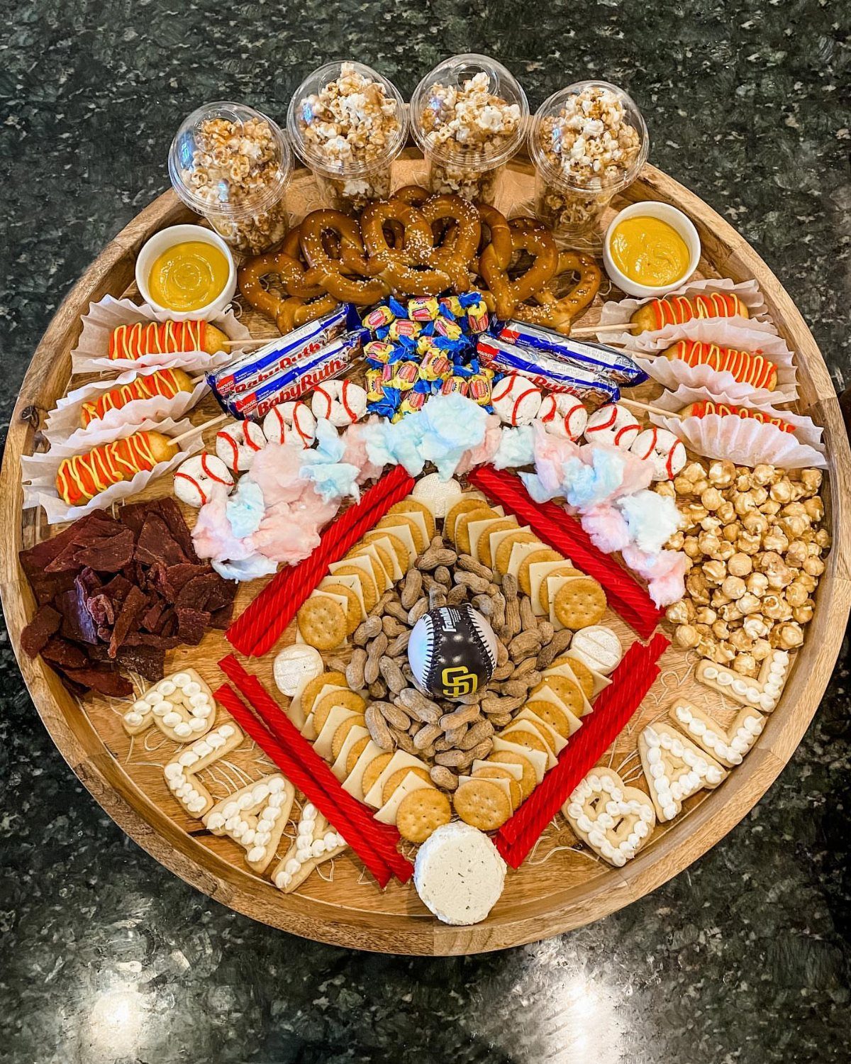 Baseball-themed snack platter with popcorn, pretzels, and crackers arranged as a baseball diamond.