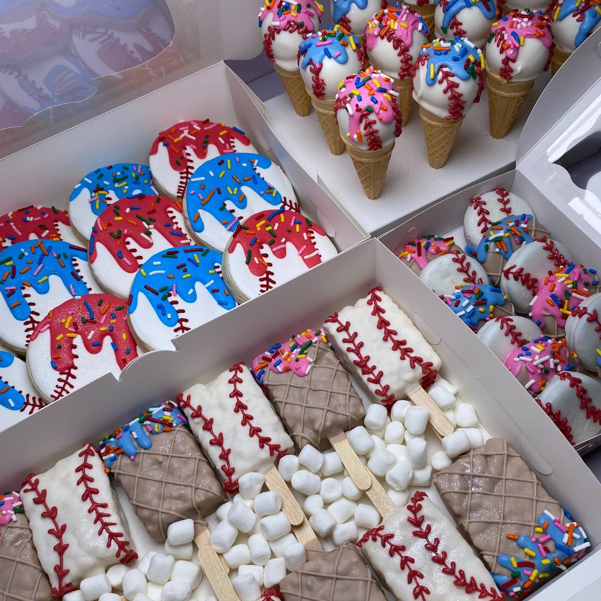 Baseball-themed desserts including decorated ice cream cones, cookies, and cake pops in boxes.