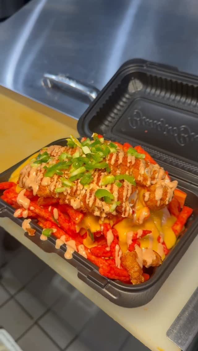 Loaded fries with melted cheese, creamy sauce, fried chicken, and green onions.