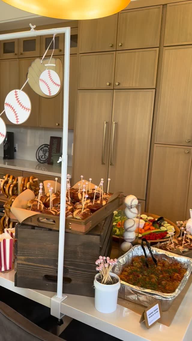 Baseball-themed food spread featuring soft pretzels on skewers and a vegetable platter.