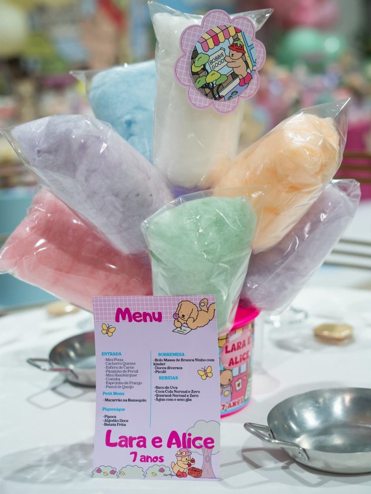 Colorful cotton candy bags arranged as a party centerpiece with a pink menu card.
