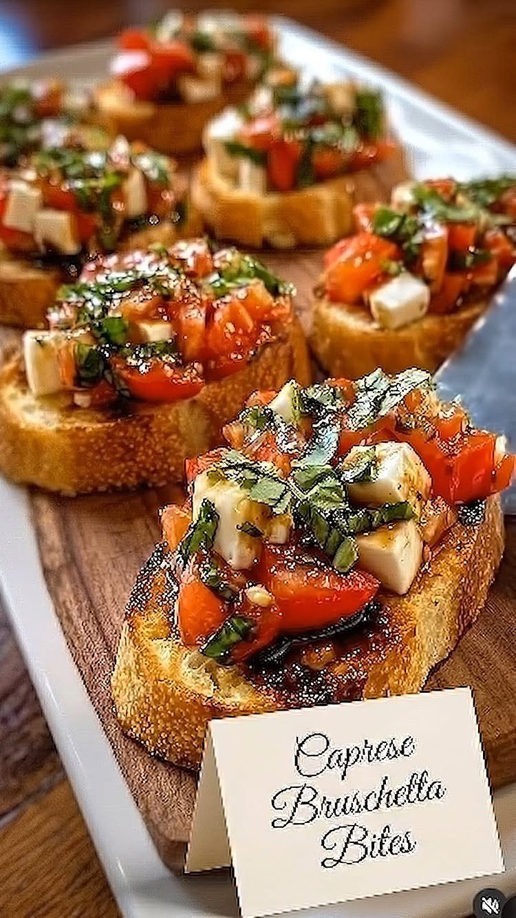 Caprese bruschetta bites with tomatoes, mozzarella, and basil on toasted baguette slices.