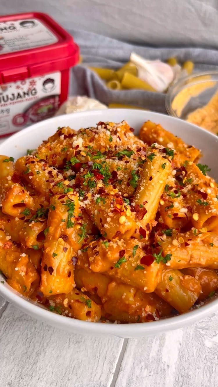 Rigatoni pasta in creamy orange sauce topped with herbs and red pepper flakes