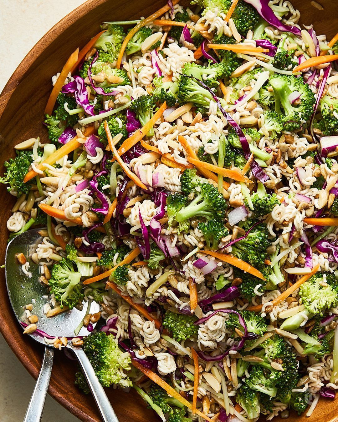 Broccoli and ramen noodle slaw with carrots and cabbage in a wooden bowl