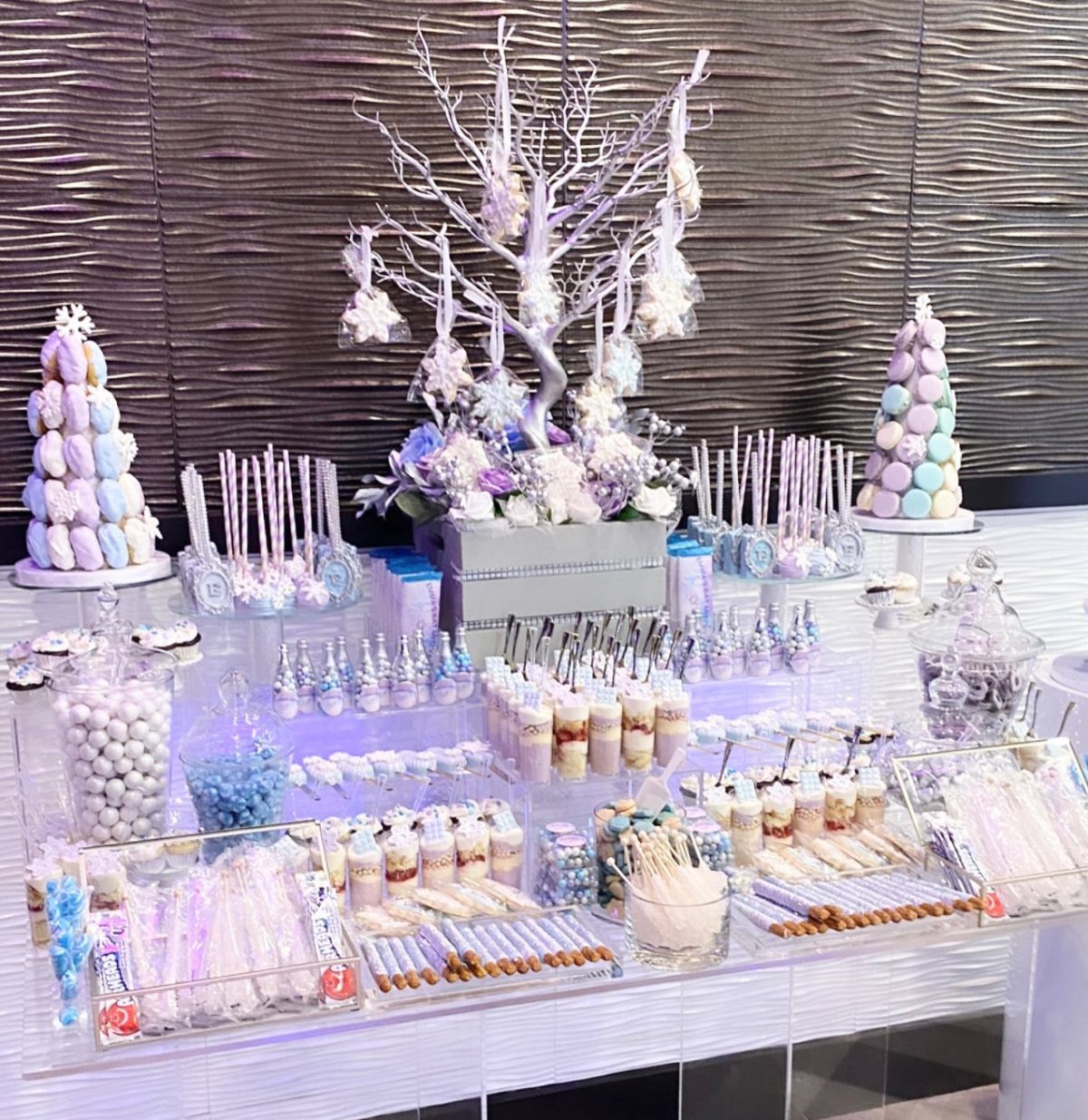 Winter themed dessert table with a white decorative tree and macaron towers.