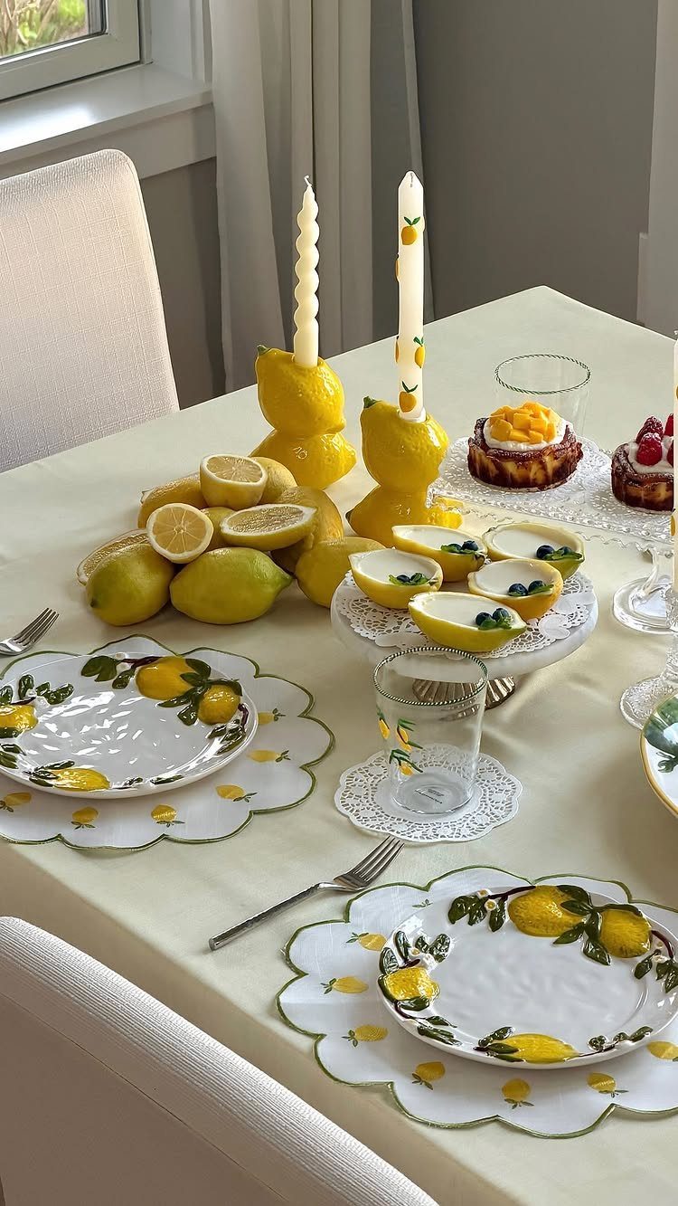 Lemon-themed dining table setting with yellow accents, fresh lemons, and matching dinnerware.
