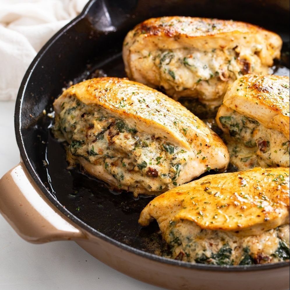 Stuffed chicken breasts with spinach and cheese in a black cast iron skillet