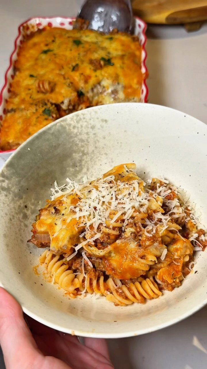 Baked rotini pasta with melted cheese and parmesan in a white bowl