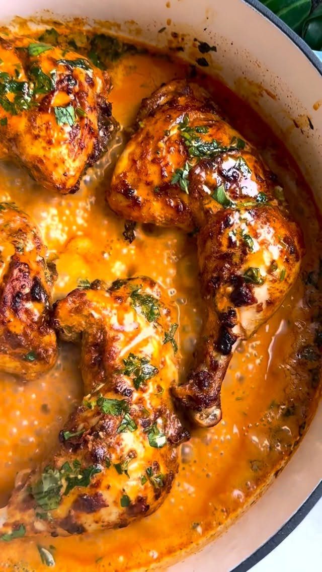 Roasted chicken leg quarters in a creamy orange curry sauce with fresh cilantro.