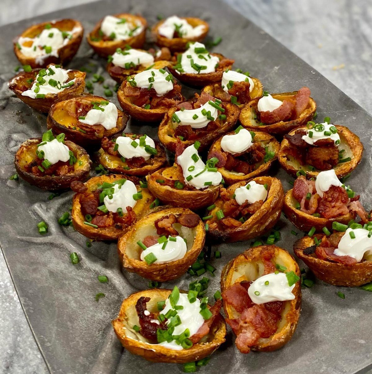 Potato skins filled with melted cheese, bacon, sour cream, and fresh chives.