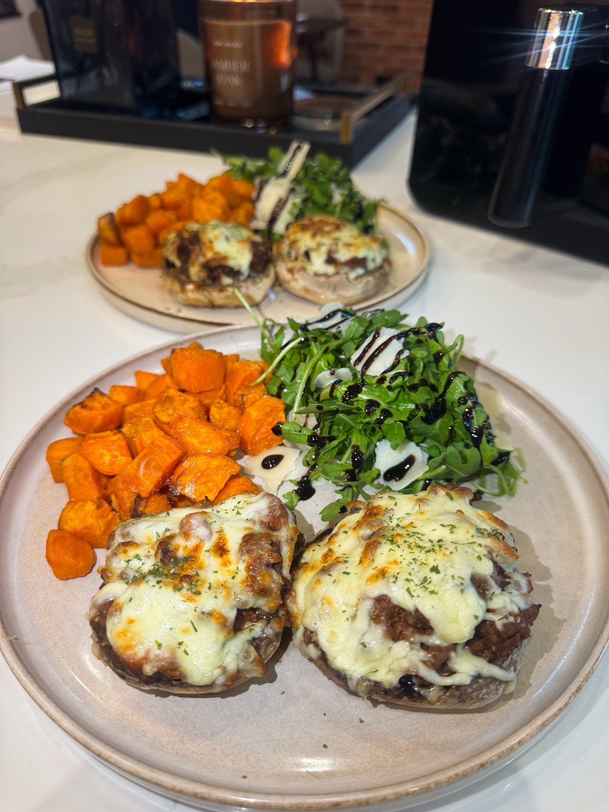 Stuffed mushrooms topped with melted cheese served with roasted sweet potatoes and salad.