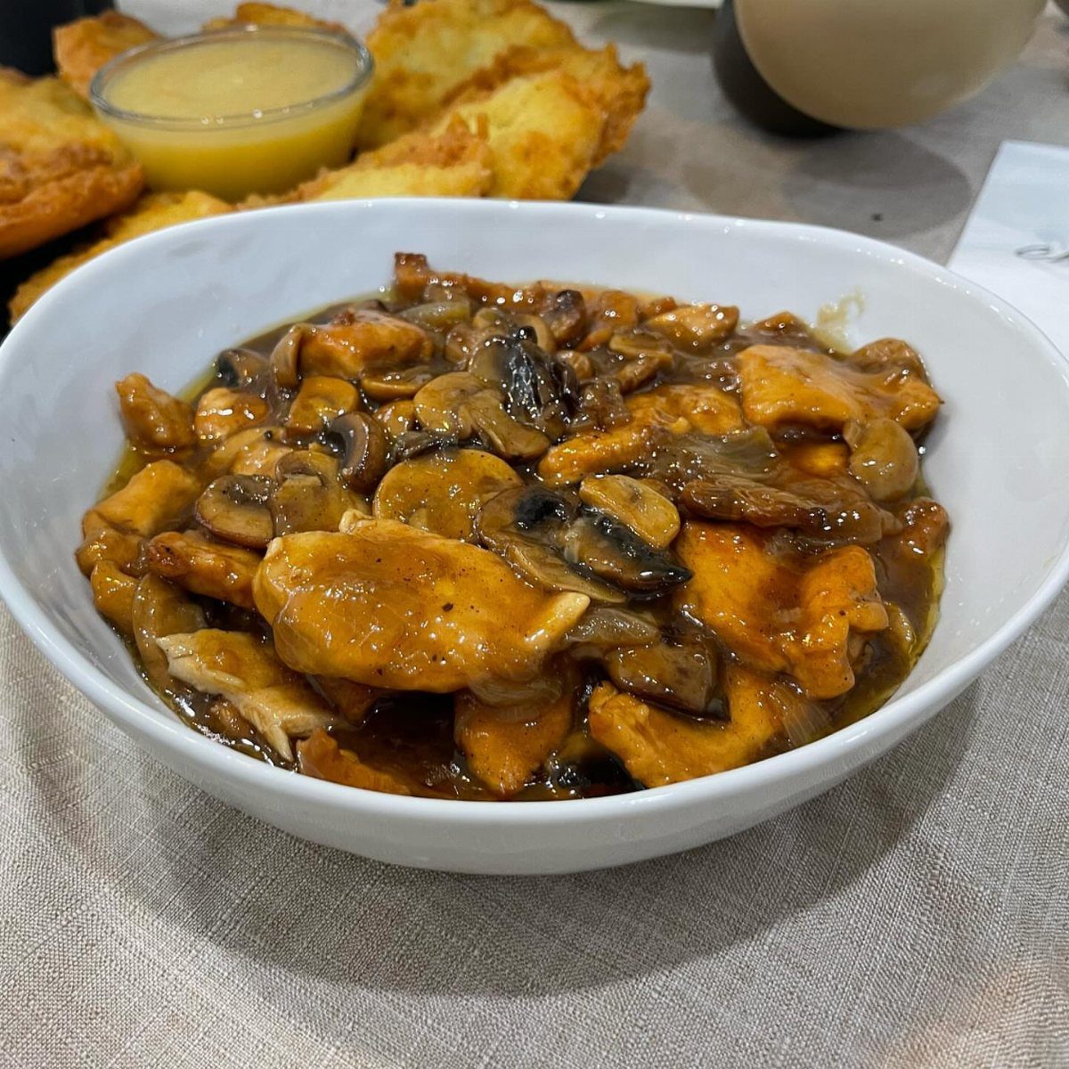 Chicken Marsala with mushrooms in a brown sauce served in a white bowl.