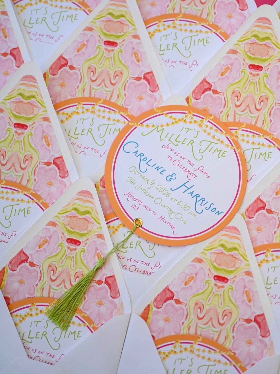 Circular and fan-shaped floral invitations for Caroline and Harrison with a green tassel.
