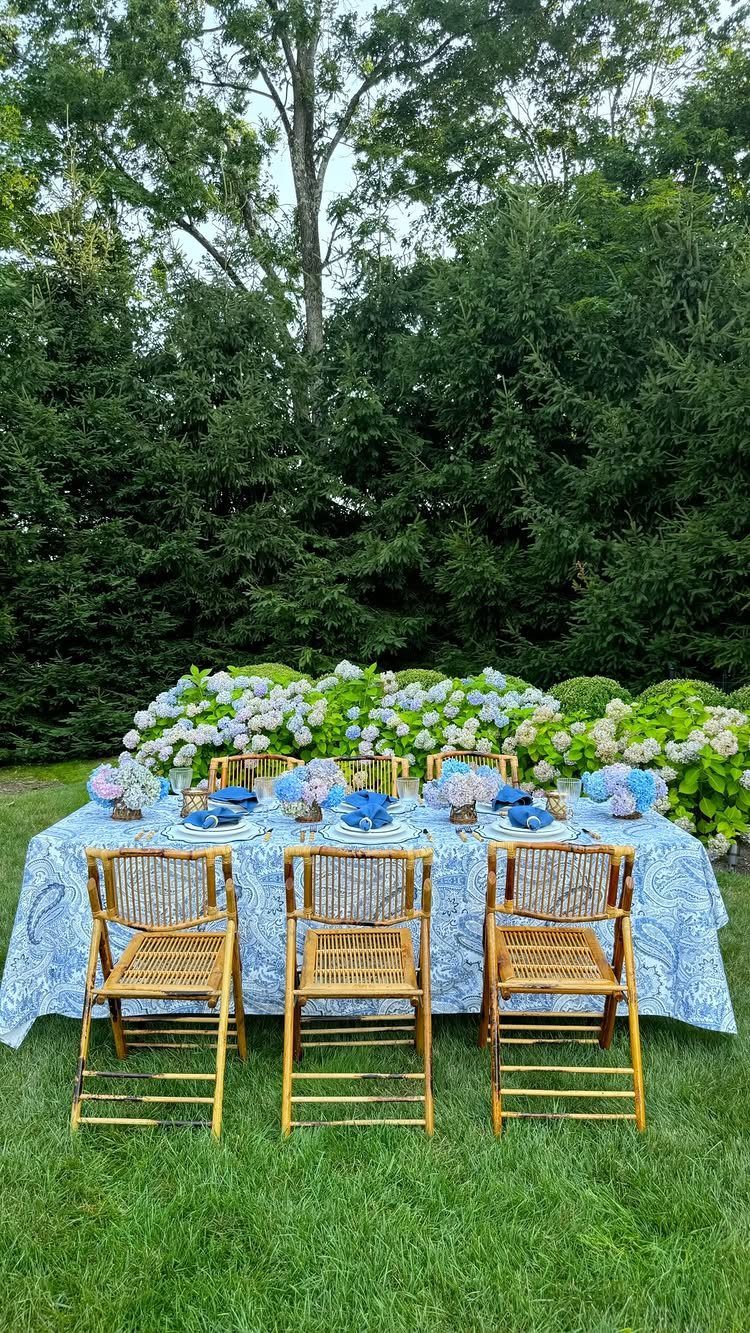 Blue and white patterned tablecloth and napkins on an outdoor dinner table setting.