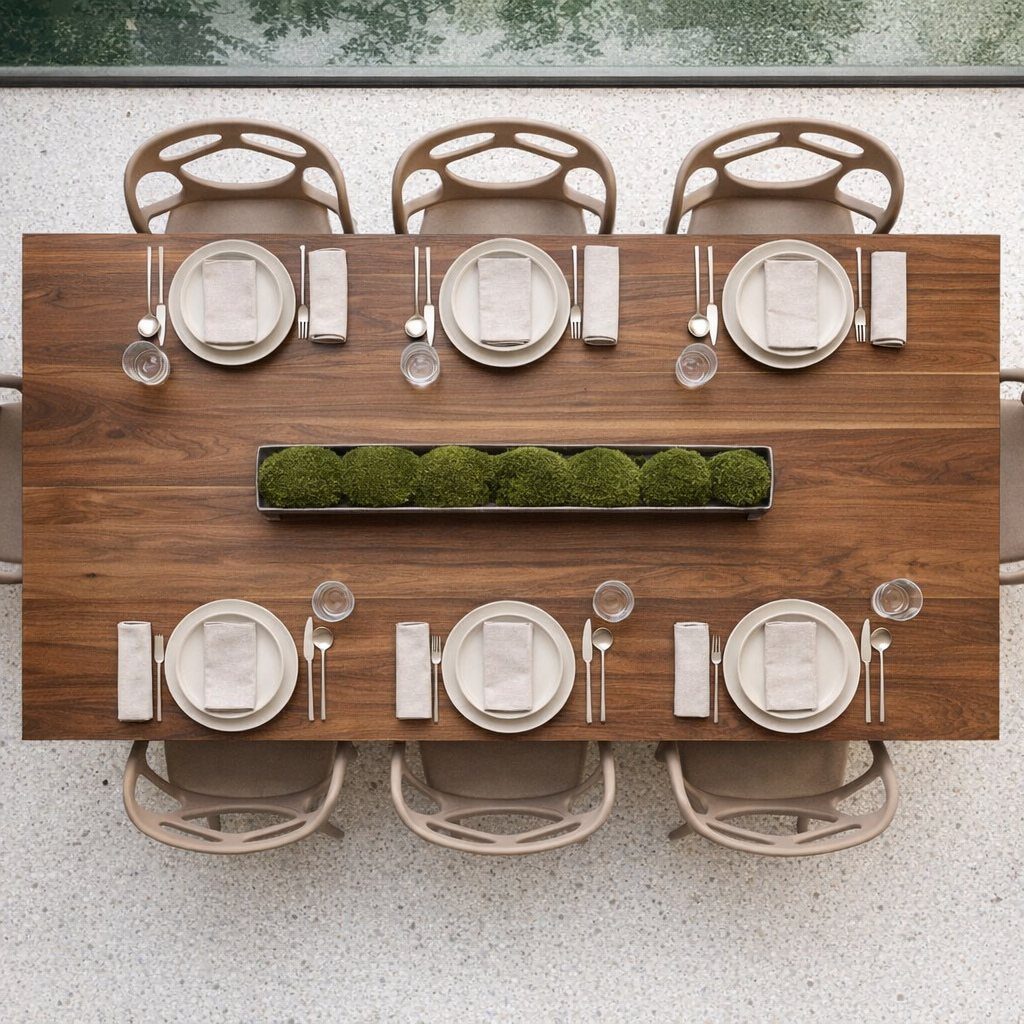 Wooden dining table set for six with a minimalist moss ball centerpiece tray.
