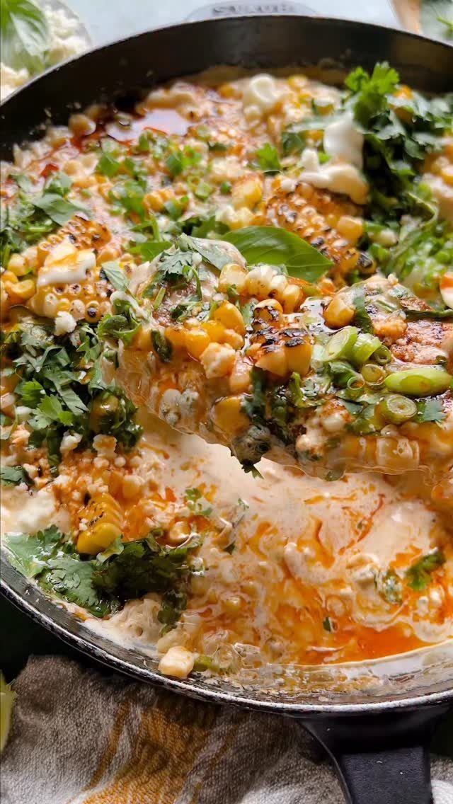 Chicken breasts with corn and melted cheese in a creamy sauce in a skillet