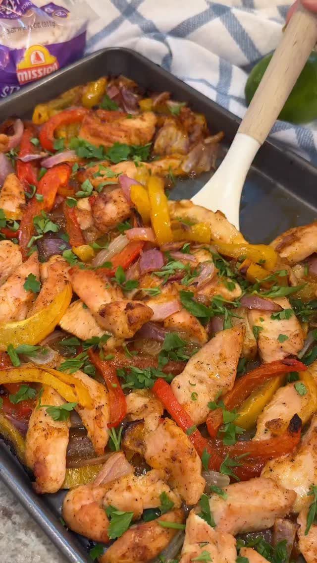 Chicken fajitas with colorful bell peppers and onions in a baking sheet