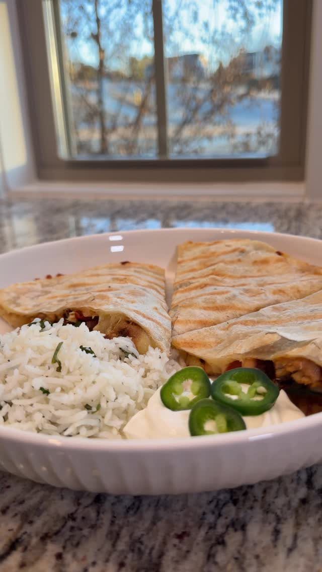 Toasted chicken quesadillas served with white rice, sour cream, and sliced jalapeños.