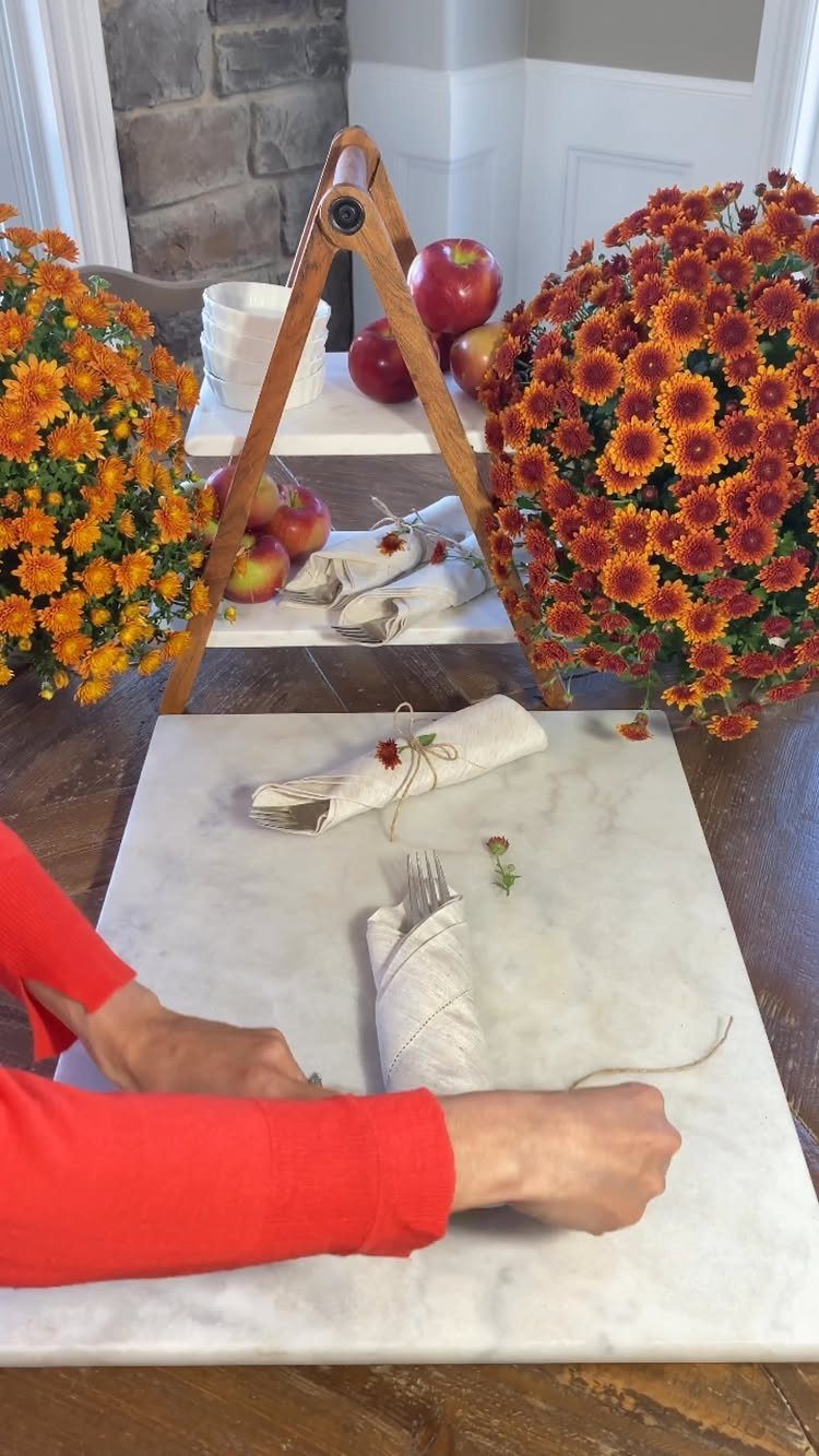 White fabric napkins folded into silverware pouches on a white marble tabletop.