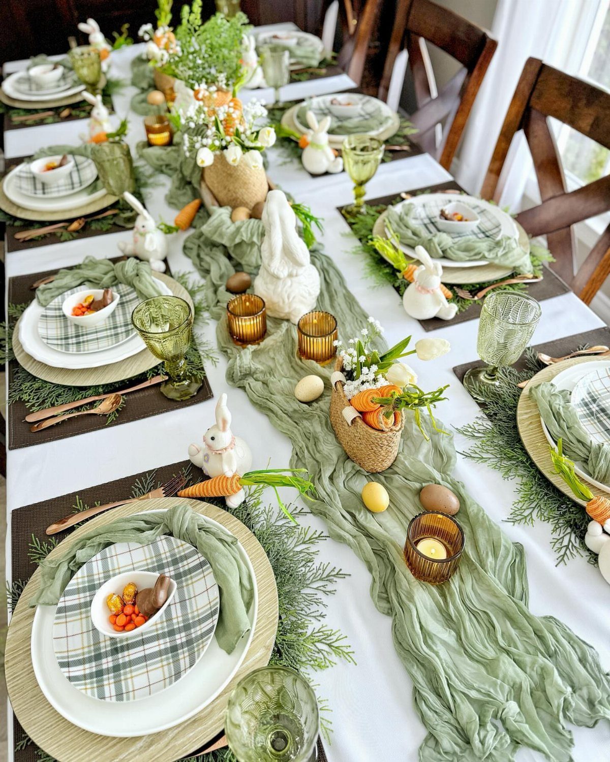 Dining table set with sage green runner, plaid plates, and white bunny figurines.