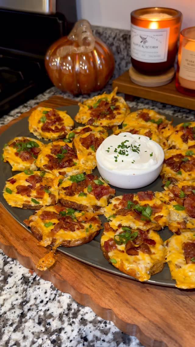 Loaded baked potato rounds with melted cheese and bacon on a platter.