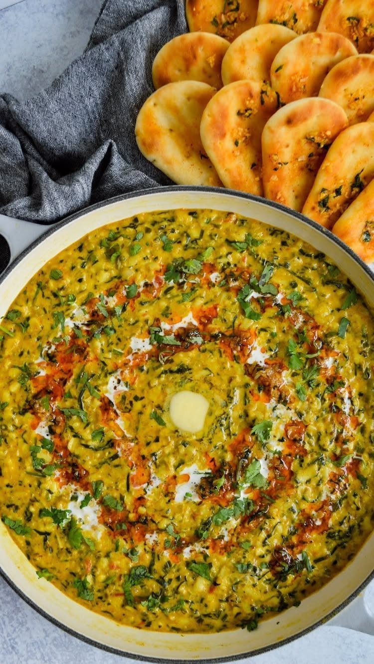 Yellow dal in a pan with cream and spices, served with garlic naan.