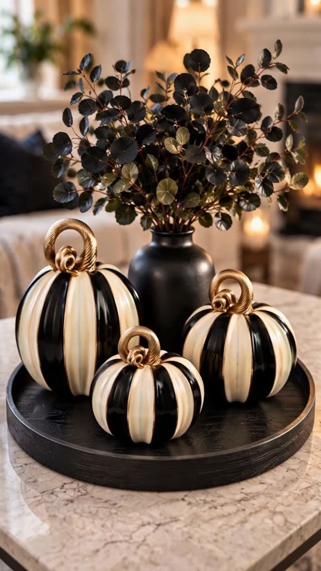 Striped pumpkins and dark foliage in a vase on a black circular tray.