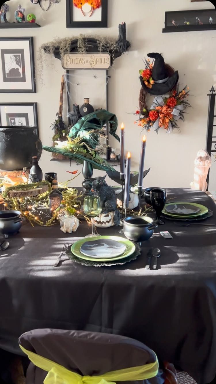 Halloween table setting with black cloth, green plates, and purple candles.