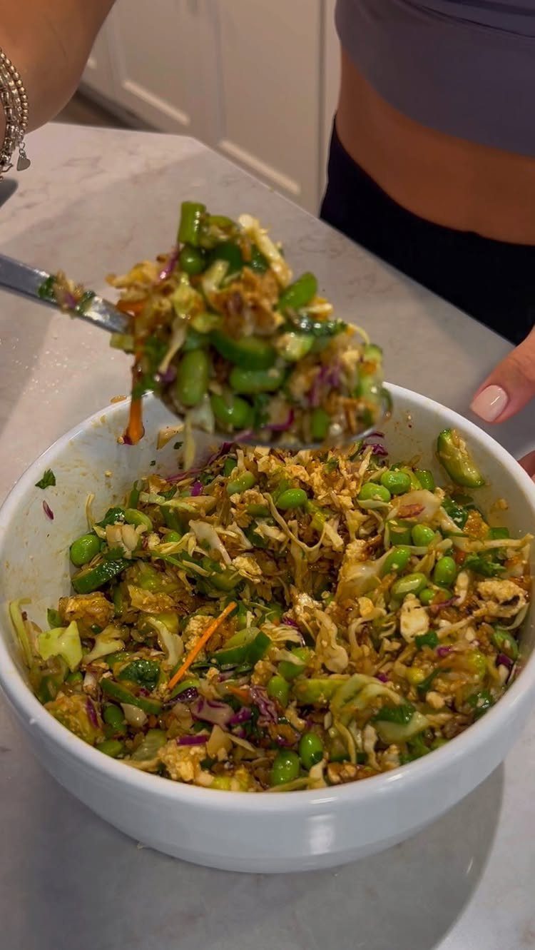 Chopped vegetable salad with edamame and cabbage in a white bowl.