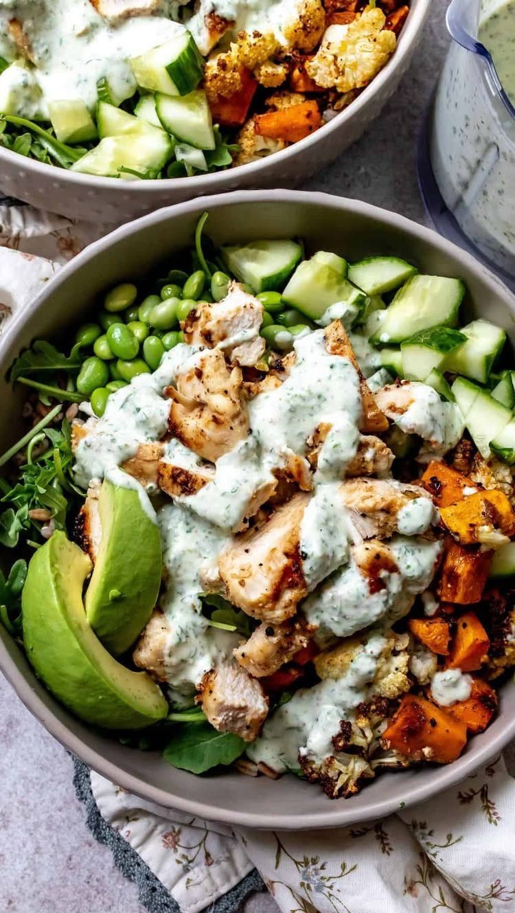 Grilled chicken and avocado power bowls with fresh vegetables and creamy green dressing.
