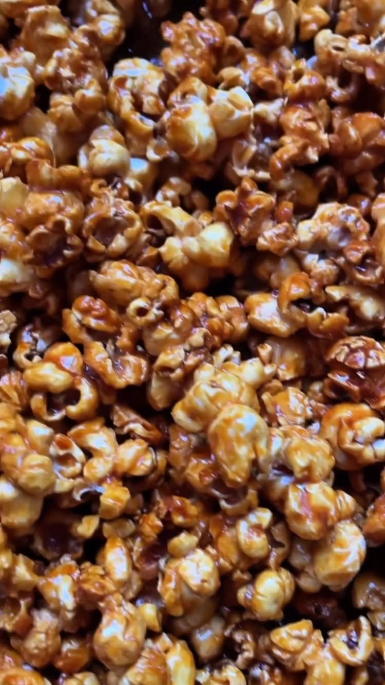 Caramel popcorn coated in a glossy, golden-brown sugar glaze in a close-up view.