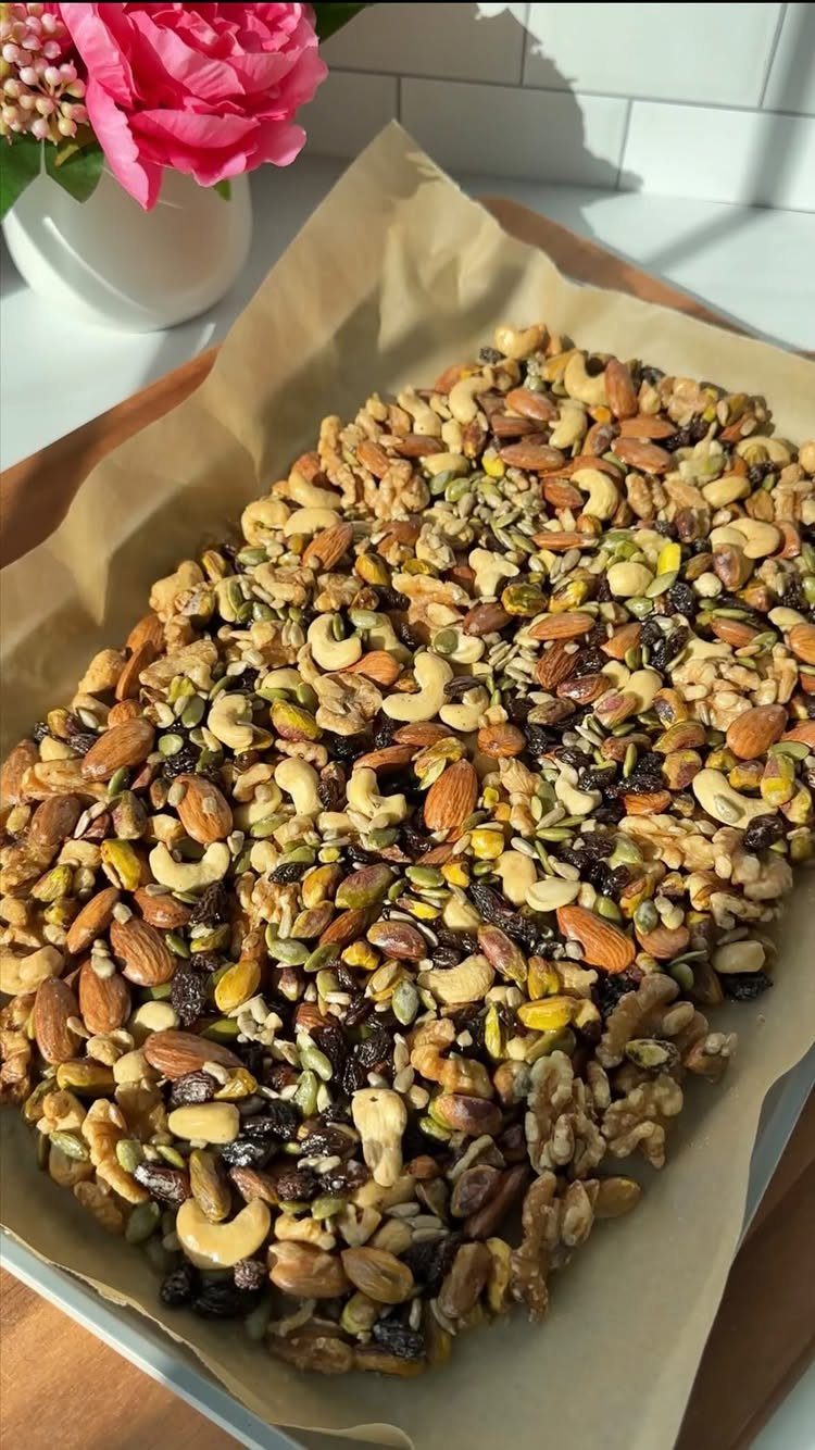 Mixed nuts and dried fruit spread on parchment paper on a baking tray