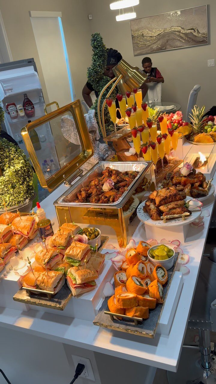 Mini sandwiches and sushi rolls on a white table with a gourmet buffet.