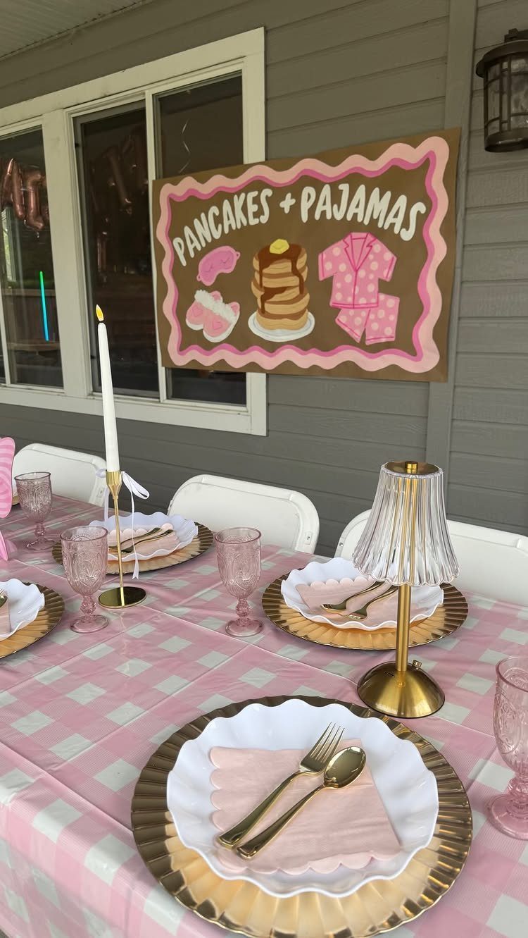 Table set with pink checkered cloth and a Pancakes and Pajamas party sign.