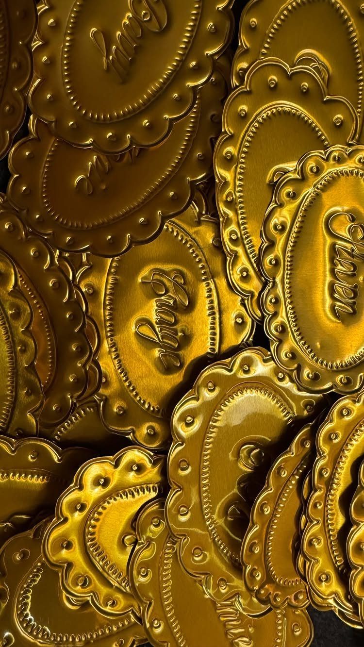 Gold metallic oval food labels with scalloped edges and embossed cursive lettering.
