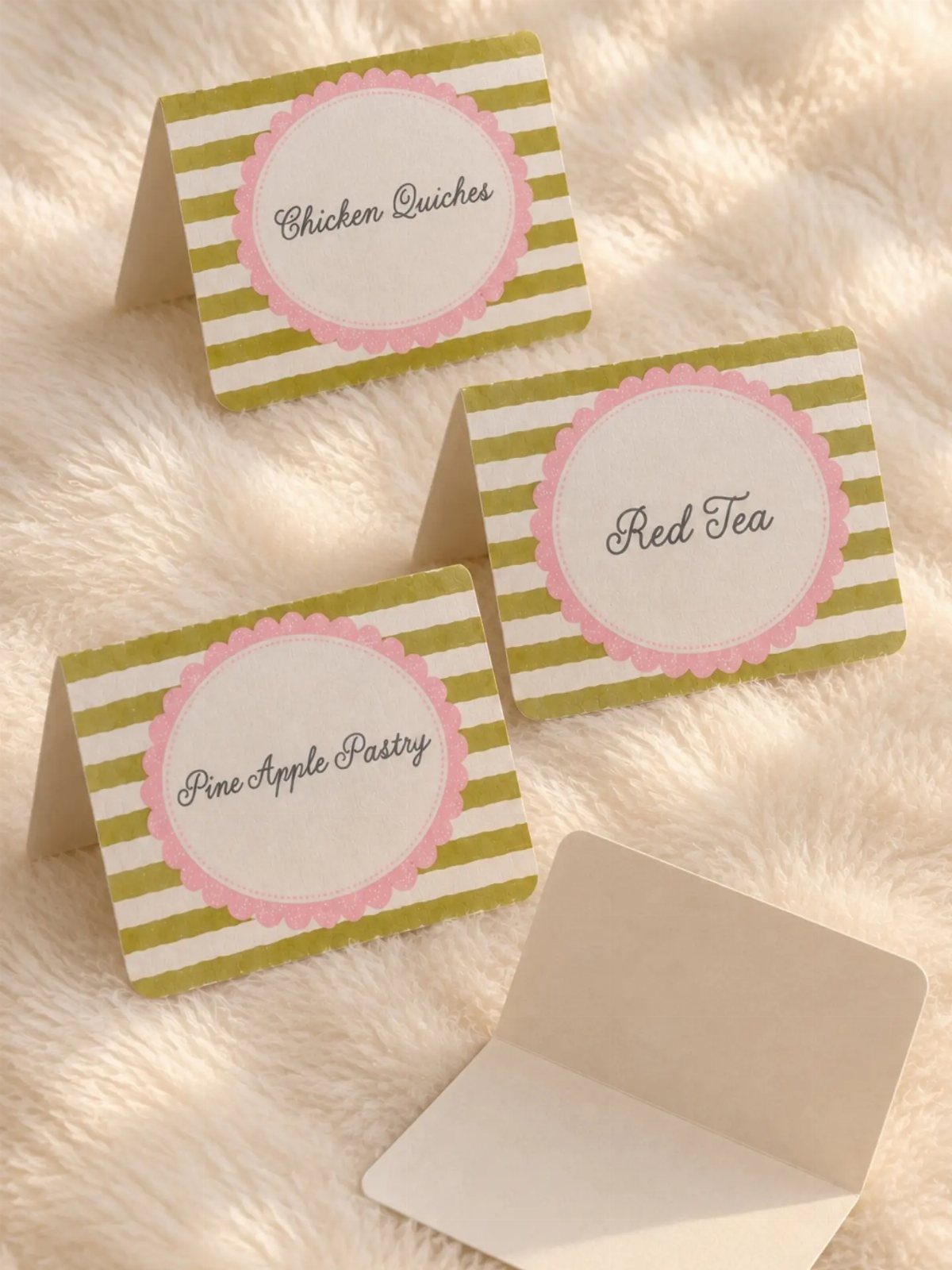 Tent-style food labels with green stripes and pink circles on white faux fur