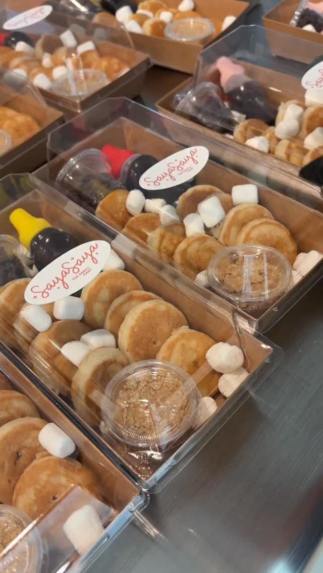Pancake cookie party favors in clear boxes with marshmallows and mini syrup bottles.