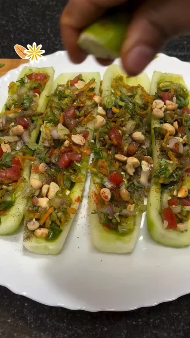 Cucumber boats filled with chopped vegetable salad on a white scalloped plate.