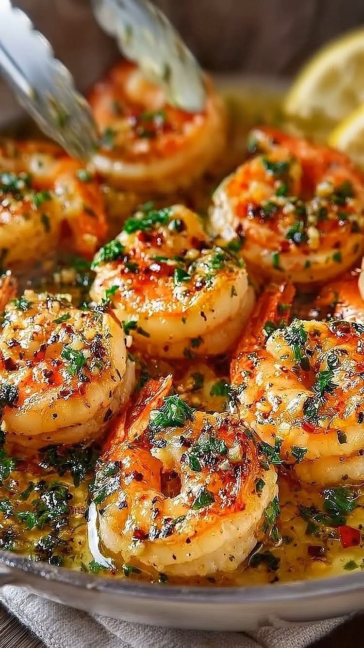 Garlic butter shrimp with parsley and red pepper flakes in a metal skillet