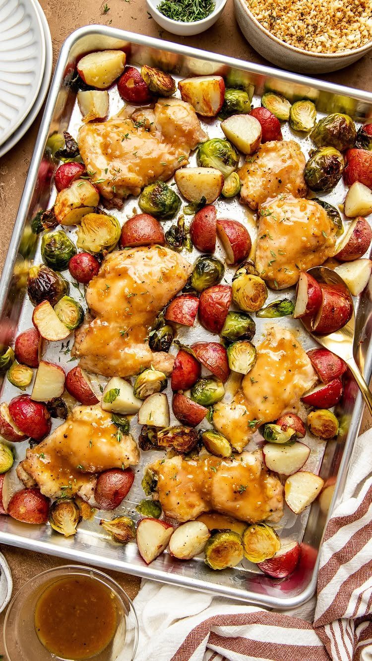 Glazed chicken thighs with roasted red potatoes and Brussels sprouts on a sheet pan