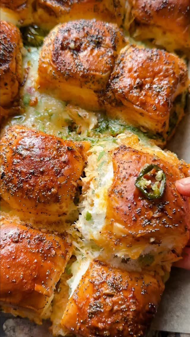 Golden-brown glazed pull-apart rolls with melted cheese and green pepper slices.