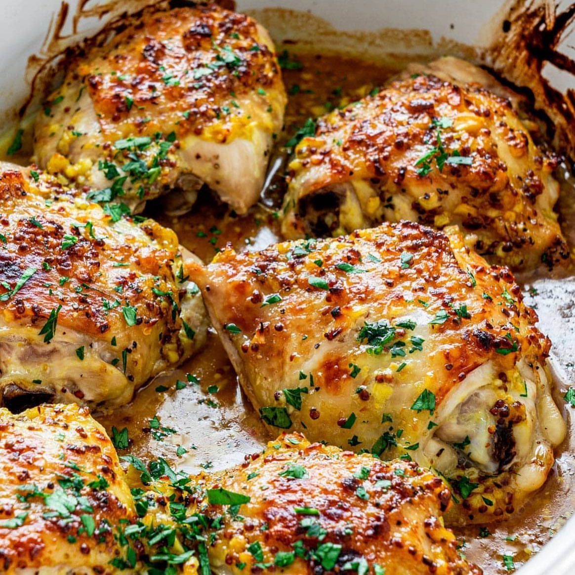 Roasted chicken thighs glazed in honey mustard and garnished with fresh parsley.