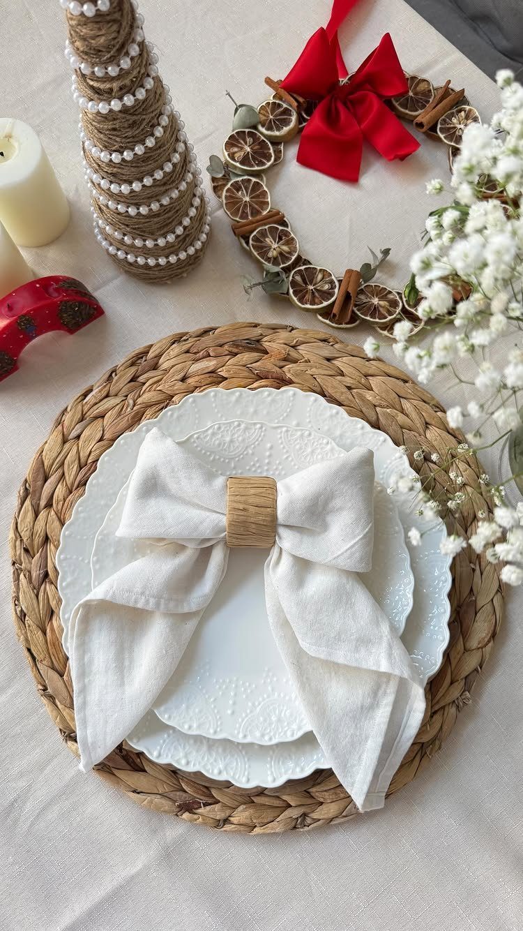 White linen napkin with a wooden ring bow on a woven charger plate.