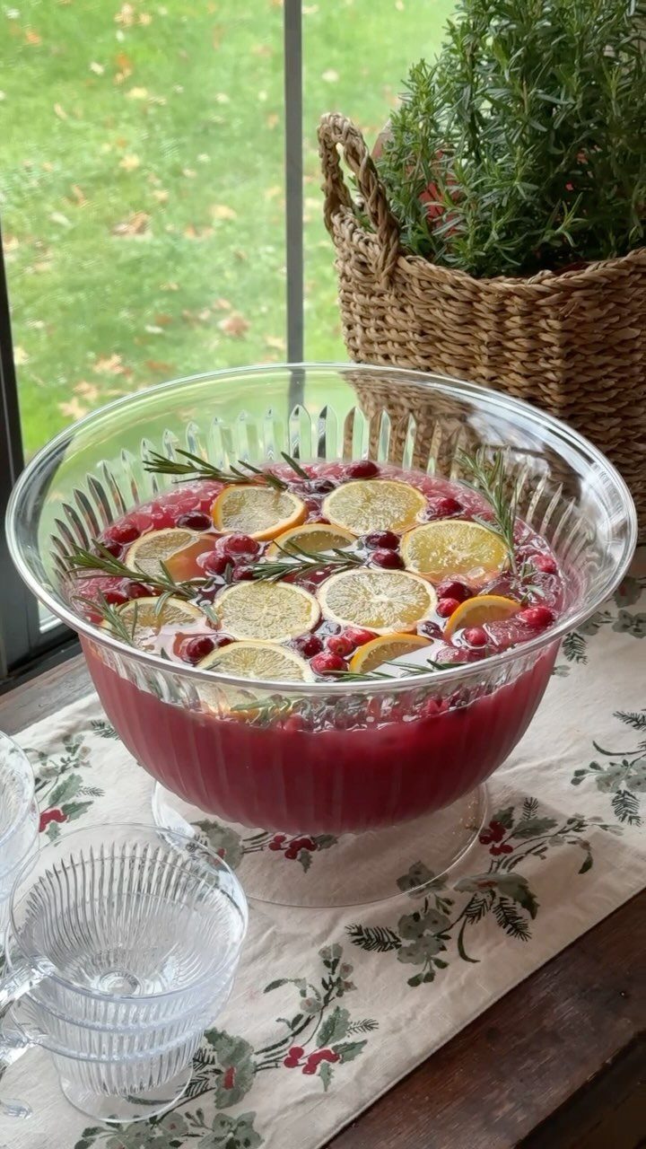 Red sangria in a glass bowl with lemon slices and rosemary sprigs