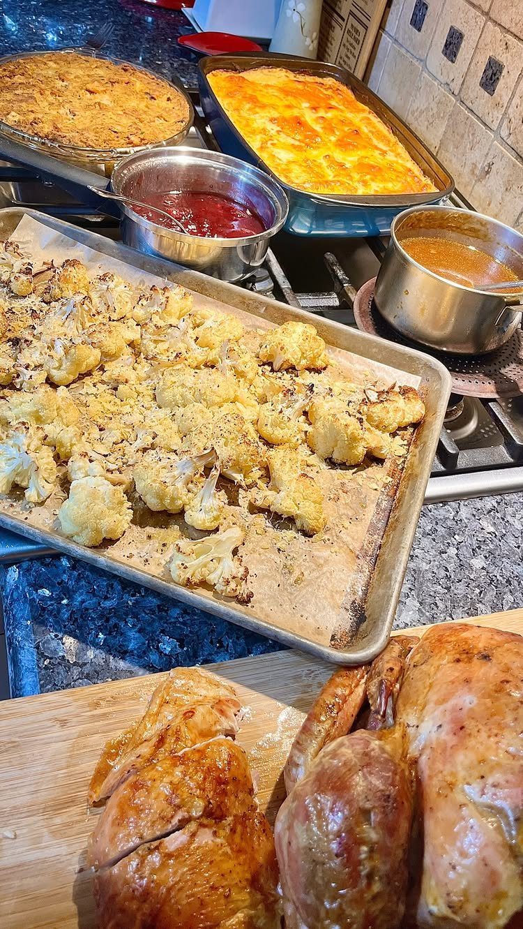 Roasted turkey, cauliflower, and various side dishes arranged on a kitchen counter.