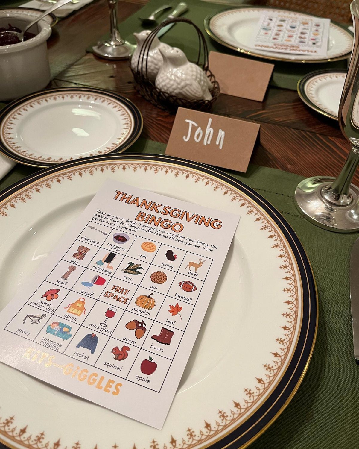 Thanksgiving table setting with white gold-rimmed plates, bingo cards, and name placecards.