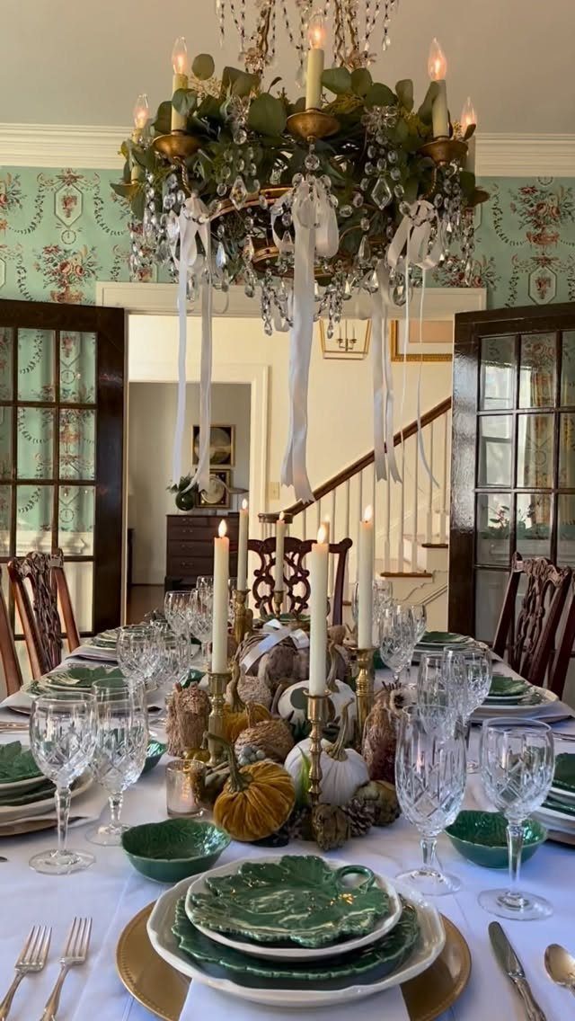 Elegant Thanksgiving table setting with green plates, gold accents, and pumpkin centerpieces.