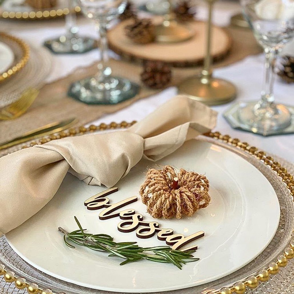 White plate with a jute pumpkin, rosemary sprig, and wooden blessed cutout.